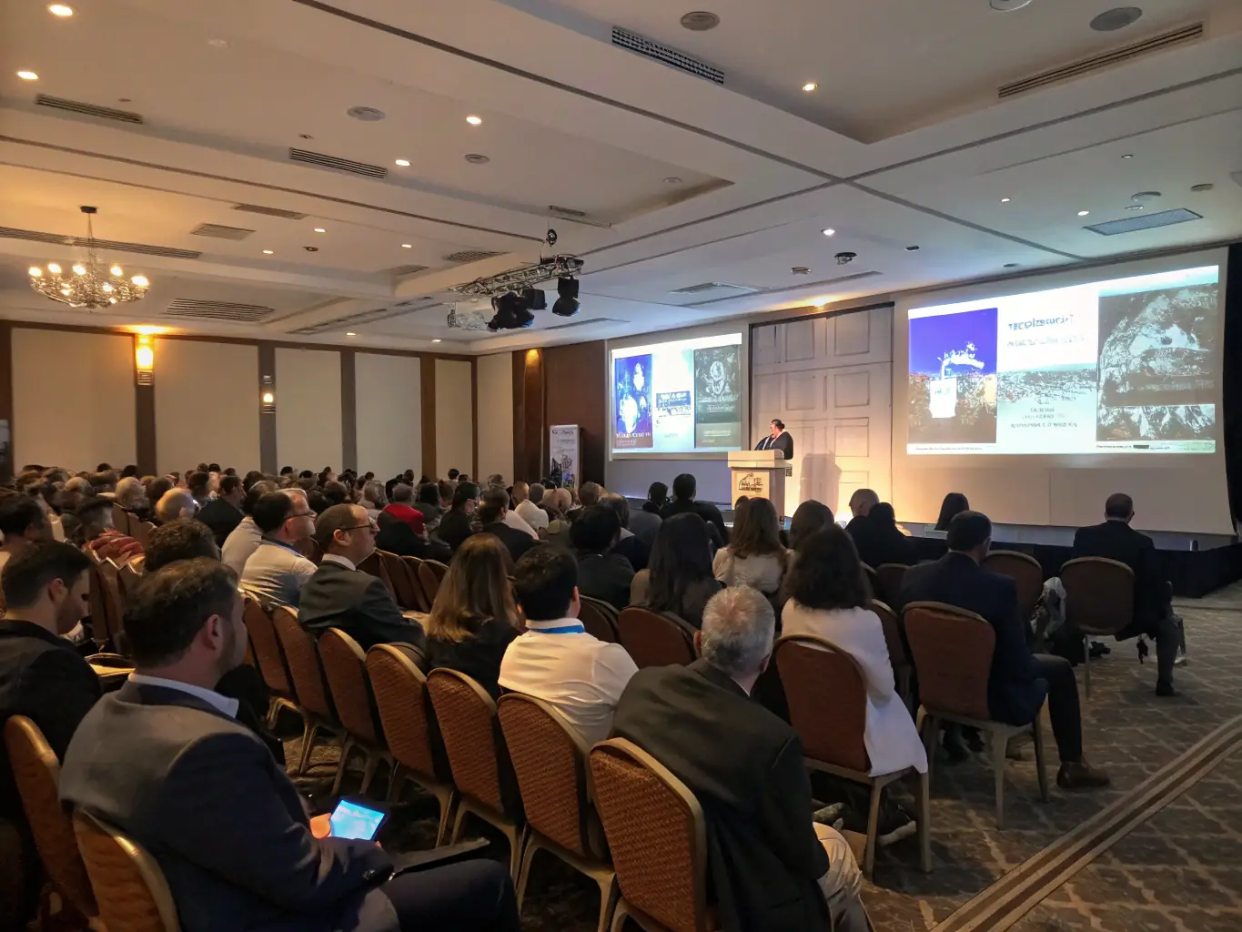 A photograph depicting a historical conference organized by MEMOIRE ET PATRIMOINE CHAUNOIS, featuring speakers and attendees engaged in discussions about local history. The image should convey a sense of intellectual curiosity and community involvement.